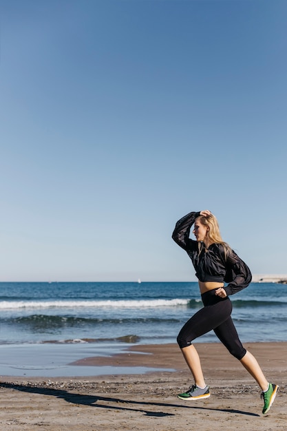 Mujer joven corriendo en la playa