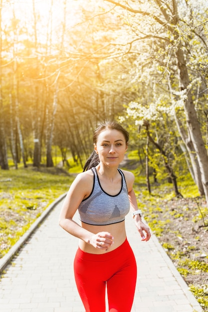 Mujer joven corriendo a través de los árboles