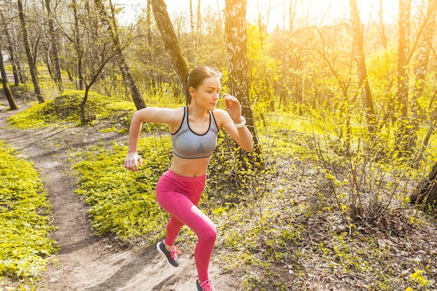 Mujer joven corriendo a través de los árboles