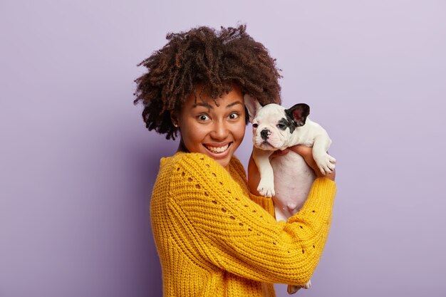 Mujer joven, con, corte de pelo afro, tenencia, perrito