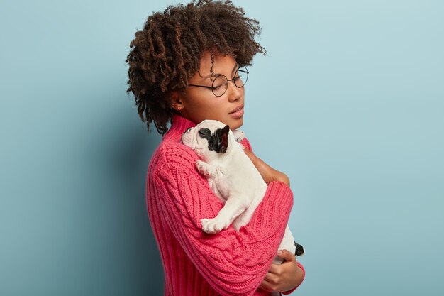 Mujer joven, con, corte de pelo afro, tenencia, perrito