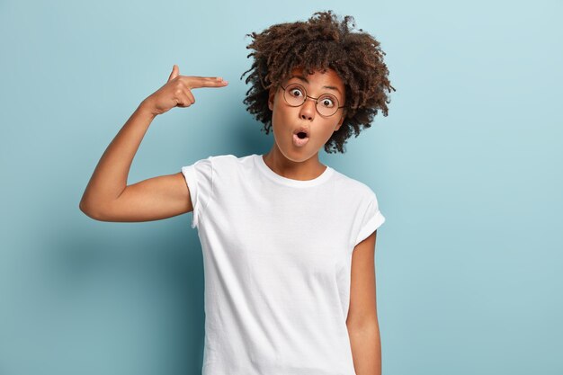 Mujer joven con corte de pelo afro vistiendo camiseta blanca