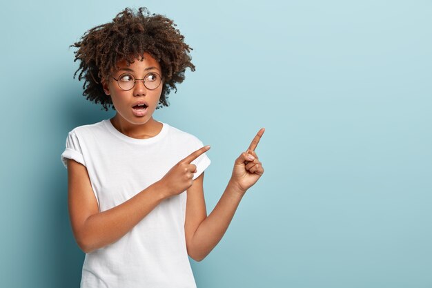 Mujer joven con corte de pelo afro vistiendo camiseta blanca