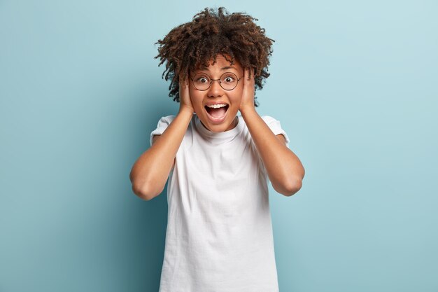 Mujer joven con corte de pelo afro vistiendo camiseta blanca