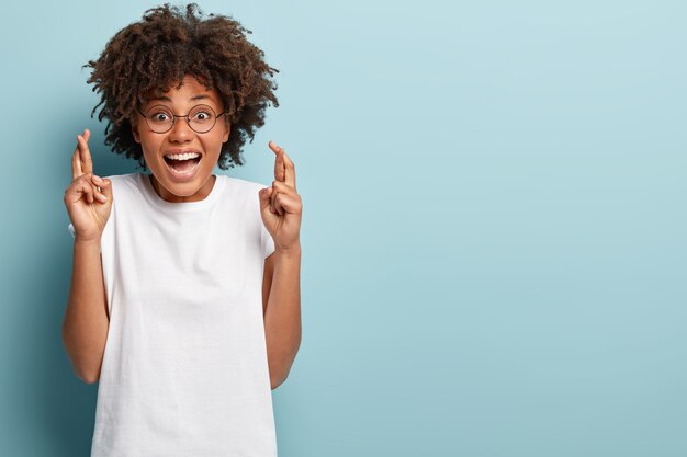 Mujer joven con corte de pelo afro vistiendo camiseta blanca