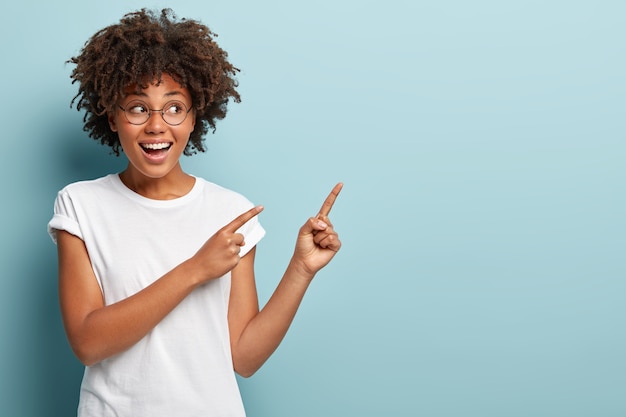 Mujer joven con corte de pelo afro vistiendo camiseta blanca