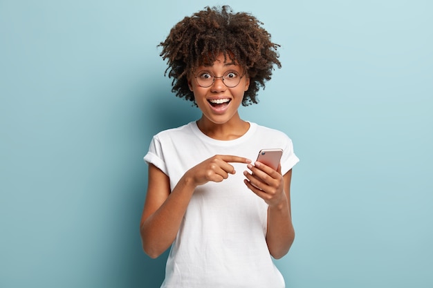 Mujer joven con corte de pelo afro vistiendo camiseta blanca