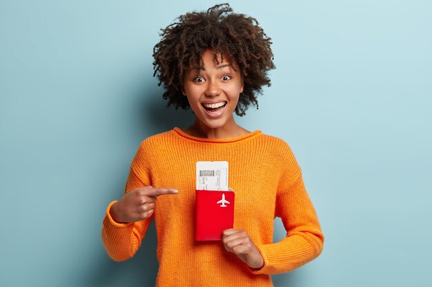 Mujer joven con corte de pelo afro vistiendo jersey naranja