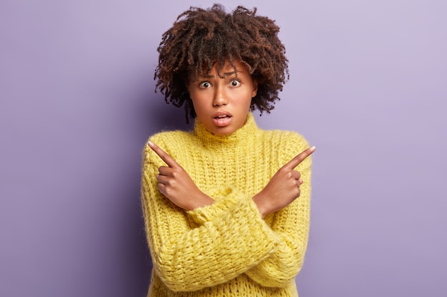 Mujer joven con corte de pelo afro vistiendo suéter amarillo