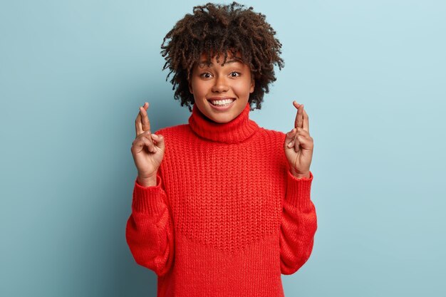 Mujer joven con corte de pelo afro vistiendo suéter rojo