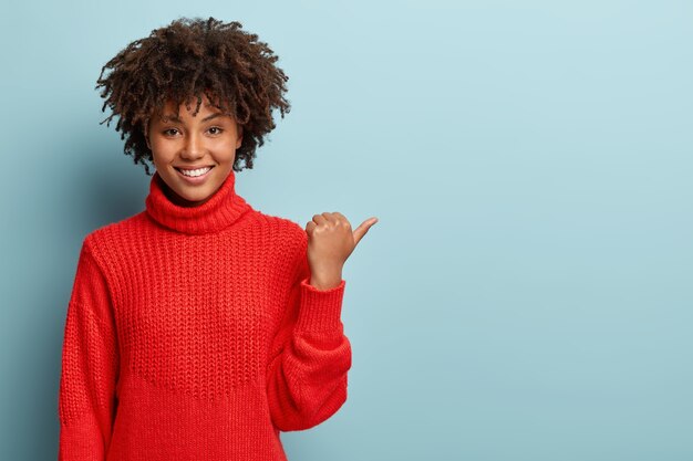 Mujer joven con corte de pelo afro vistiendo suéter rojo