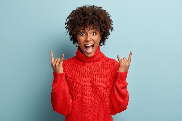 Mujer joven con corte de pelo afro vistiendo suéter rojo