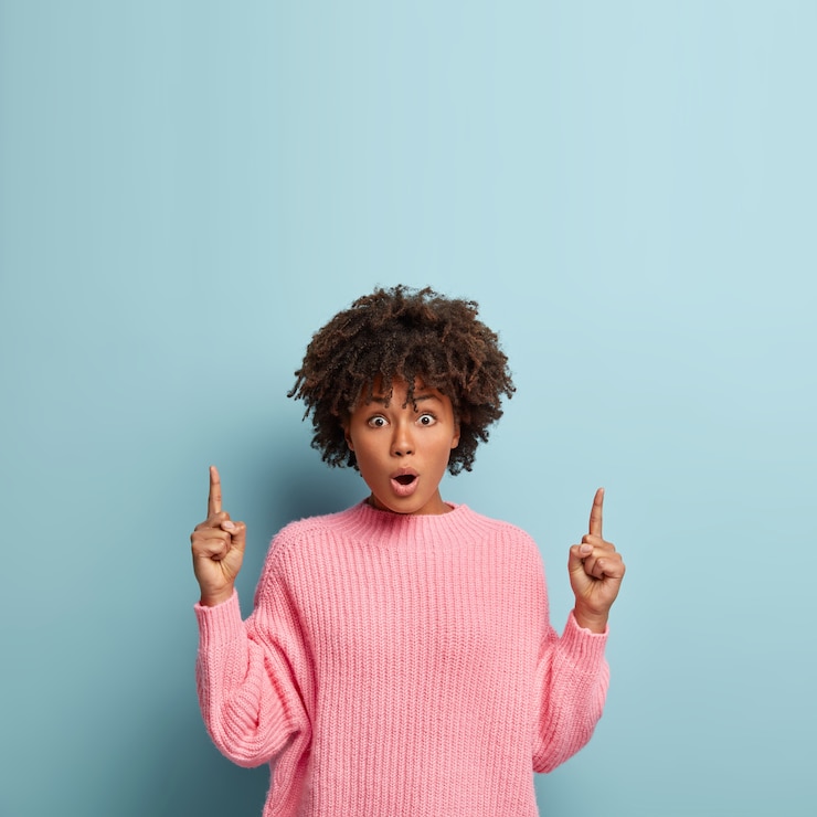 Foto gratuito mujer joven con corte de pelo afro vistiendo suéter rosa