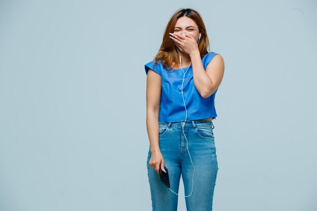 Mujer joven cubriendo la boca mientras sonríe