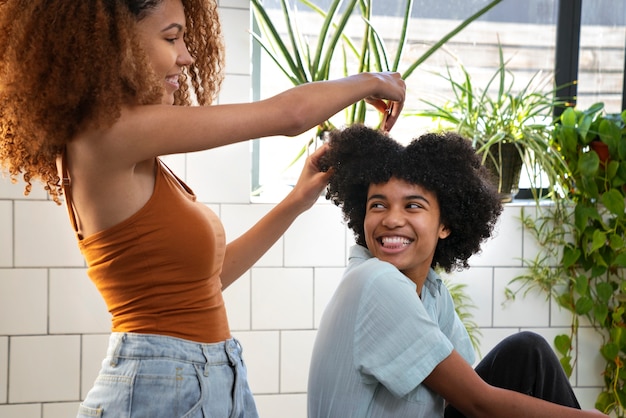 Mujer joven cuidando el cabello afro del niño