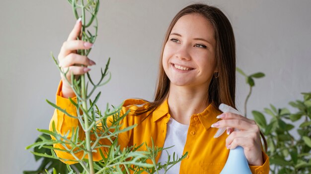 Mujer joven cuidando sus plantas en casa