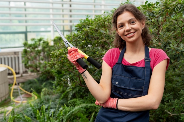 Foto gratuita mujer joven cuidando sus plantas