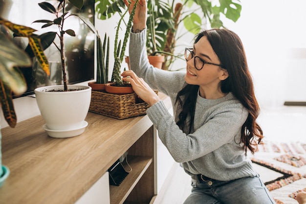 Mujer joven cultivando plantas en casa