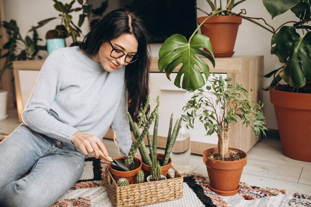 Mujer joven cultivando plantas en casa