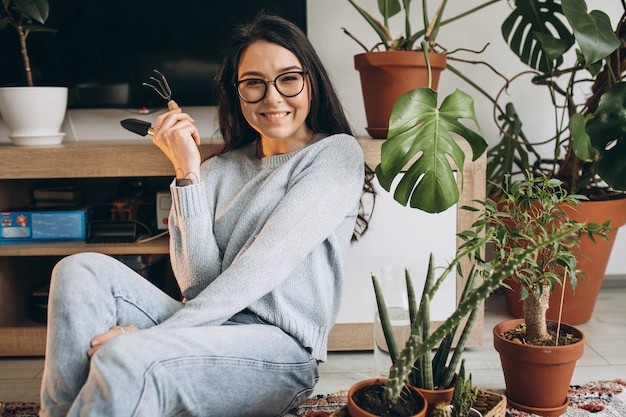 Mujer joven cultivando plantas en casa