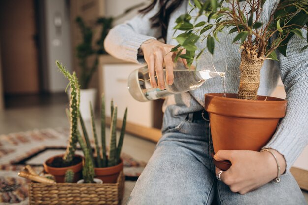 Mujer joven cultivando plantas en casa