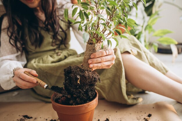 Mujer joven cultivando plantas en casa