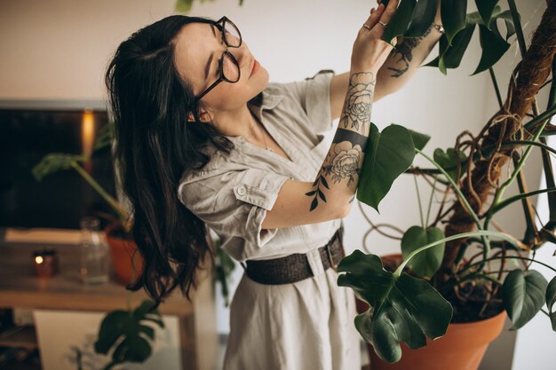 Mujer joven cultivando plantas en casa