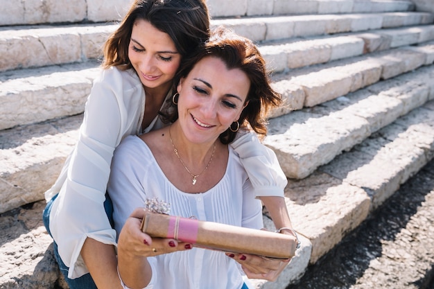 Foto gratuita mujer joven dando presente a la madre