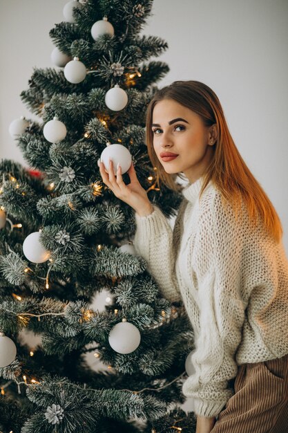 Mujer joven decorar el árbol de navidad