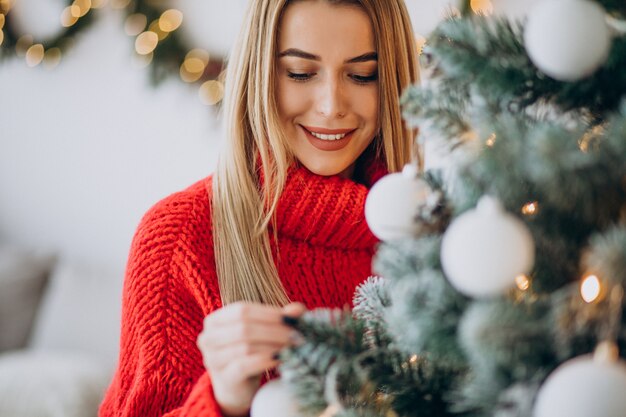 Mujer joven decorar el árbol de navidad