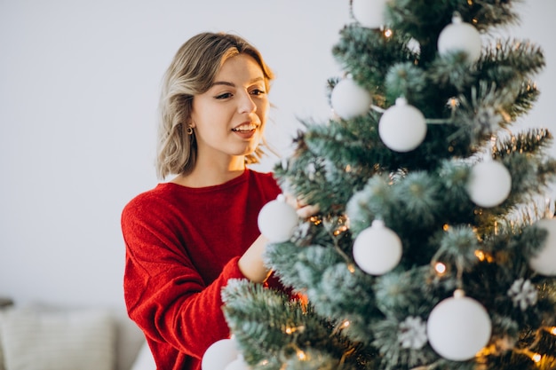 Mujer joven decorar el árbol de navidad