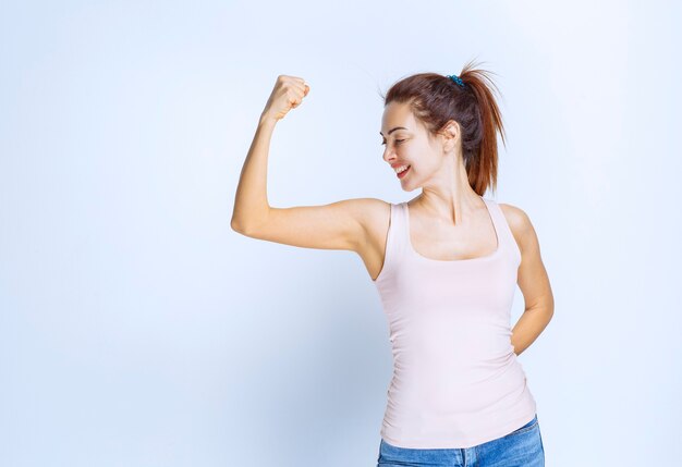 Mujer joven, demostración, ella, músculos del brazo, vista de perfil