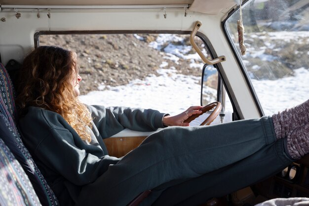 Foto gratuita mujer joven dentro de una autocaravana durante el viaje de invierno