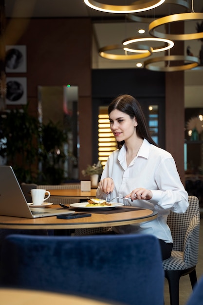 Mujer joven desayunando en un restaurante de hotel