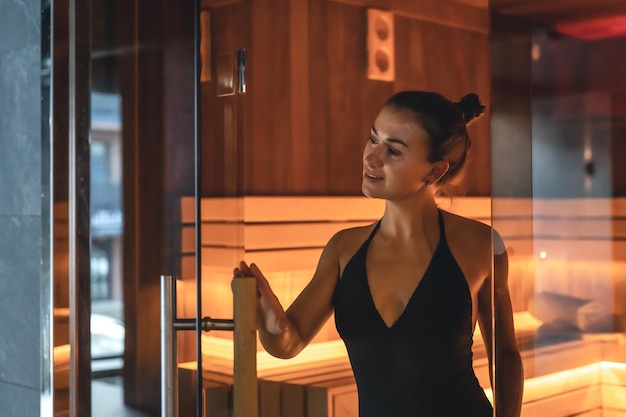 Una mujer joven descansando sola en la sauna