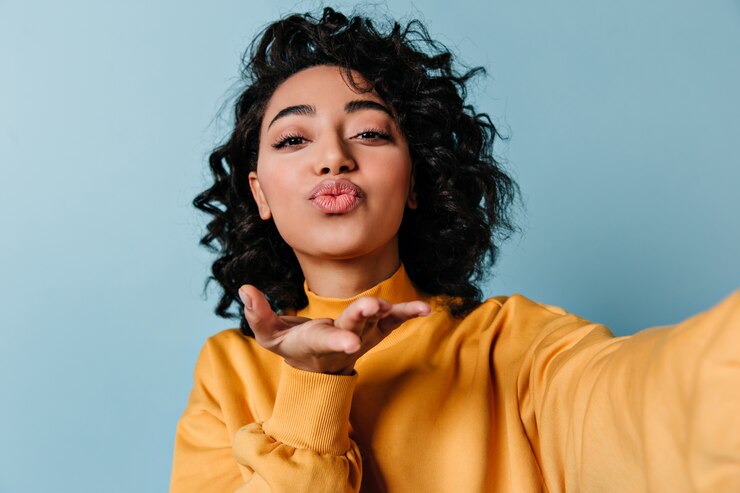 Foto gratuito mujer joven despreocupada enviando beso de aire