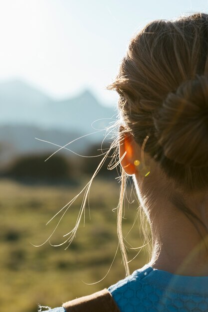 Mujer joven por detrás mirando al sol