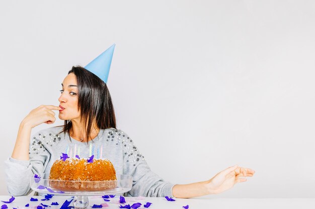 Foto gratuita mujer joven detrás de tarta de cumpleaños