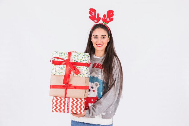 Mujer joven con diadema de astas de ciervo y cajas de regalo.