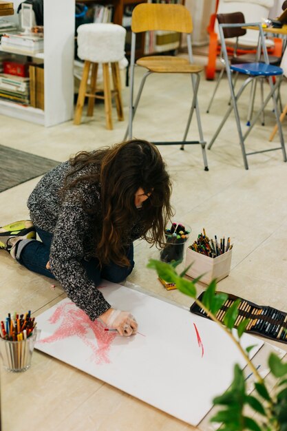 Mujer joven dibujando en el piso