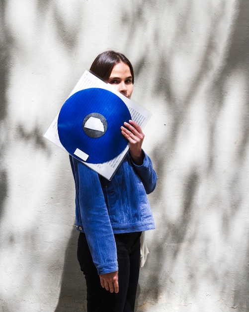 Foto gratuita mujer joven con un disco de vinilo