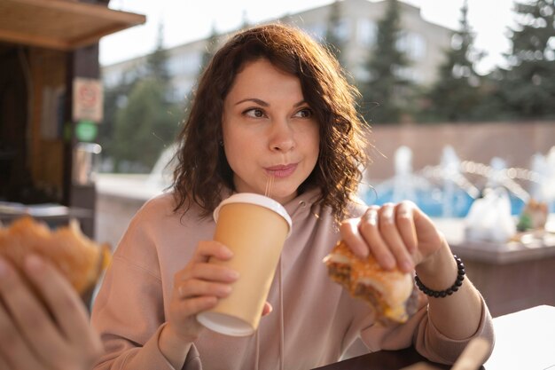 Mujer joven disfrutando de algo de comida en la calle