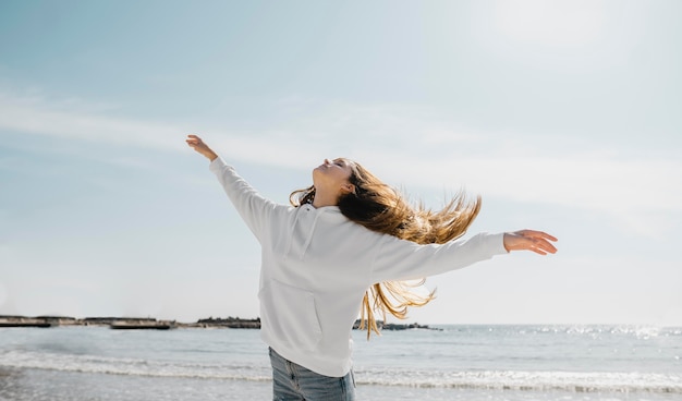 Mujer joven disfrutando de la brisa del mar