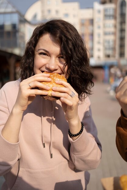 Mujer joven disfrutando de comida en la calle al aire libre
