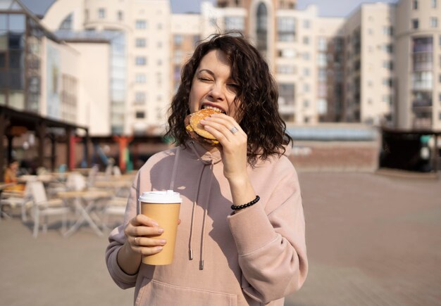 Mujer joven disfrutando de comida en la calle al aire libre