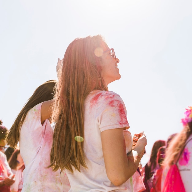 Mujer joven disfrutando del festival holi con su amiga