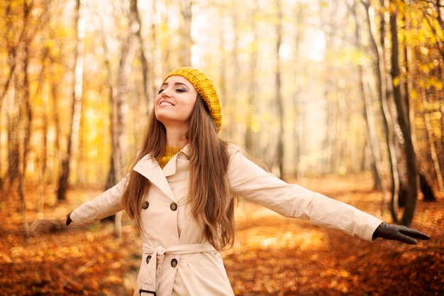 Mujer joven disfrutando de la naturaleza en otoño