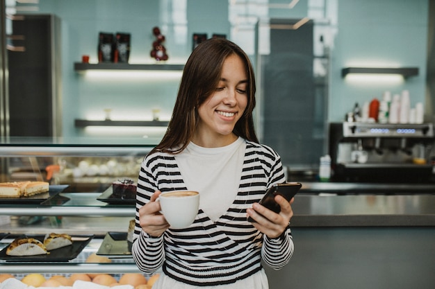 Foto gratuita mujer joven disfrutando de una taza de café