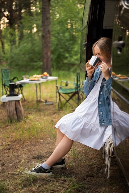 Mujer joven disfrutando del tiempo en el camping