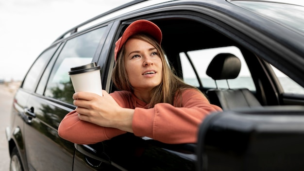 Mujer joven disfrutando de viaje por carretera